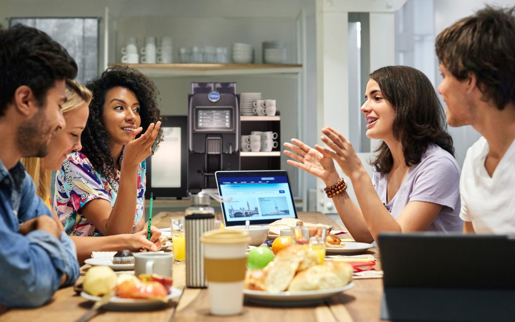 coworkers discuss workplace wellness over coffee and breakfast