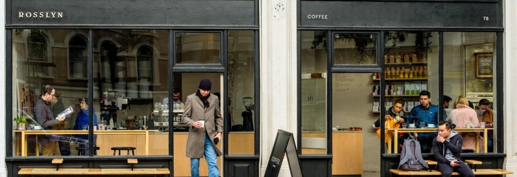 a man stands outside a specialty coffee shop