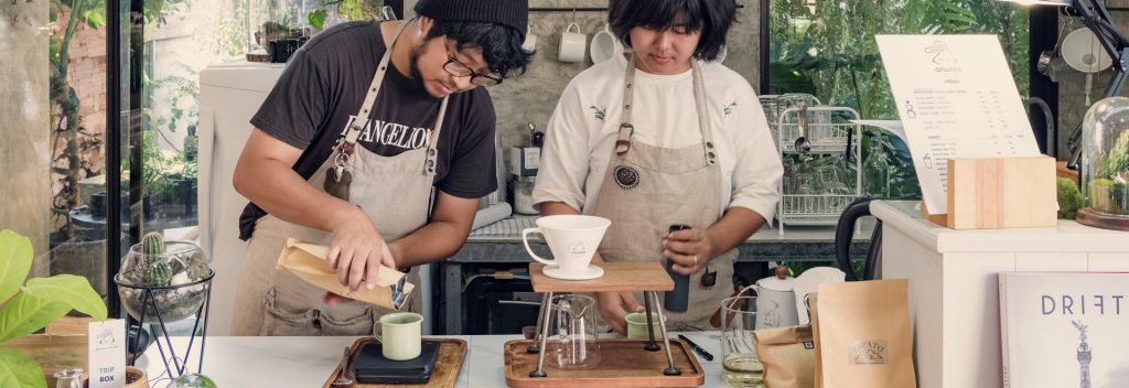 Unidentified specialty coffee baristas brewing coffee in a modern hipster coffee shop cafe in Chiang Mai, Thailand.