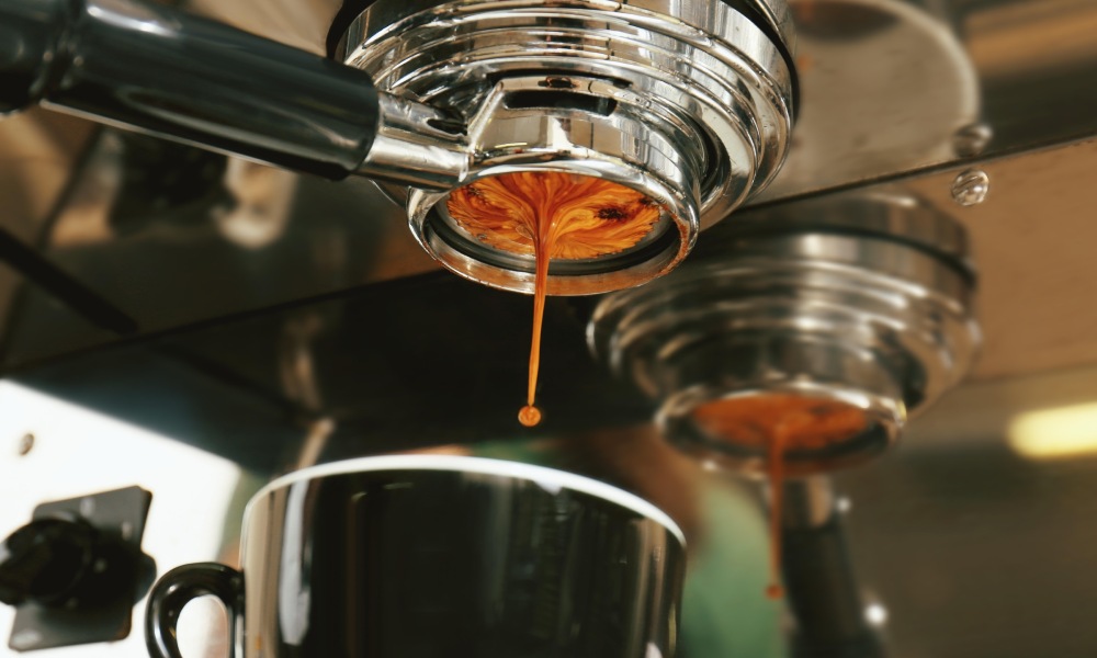A shot of espresso pouring into a cup